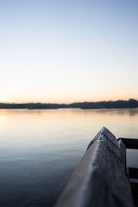 Close-up of pier railing on lake against sky