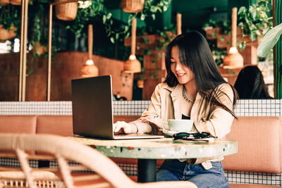 Young woman using mobile phone in cafe