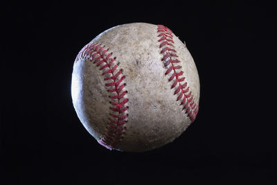 Close-up of baseball against black background