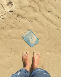 Low section of person standing on sand