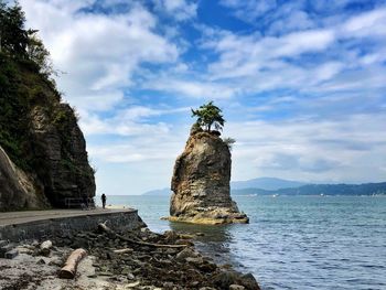 Rock formation on beach against sky