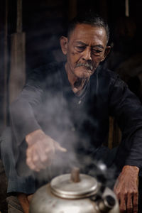 Portrait of senior man working at kitchen