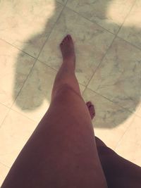 Low section of man on tiled floor