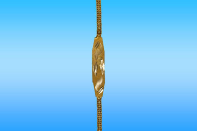 Close-up of metal hanging against blue background