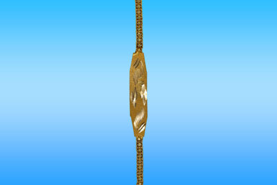 Close-up of metal hanging against blue background