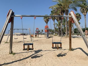 View of swing in playground against clear blue sky