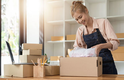 Side view of young woman using laptop while sitting at home