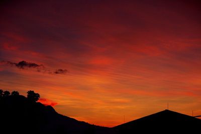 Low angle view of silhouette trees against dramatic sky