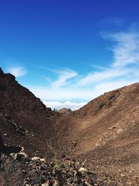 Scenic view of mountains against blue sky