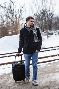 Young man standing on snow covered landscape