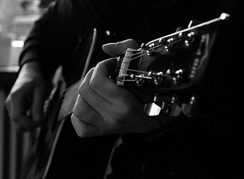 Midsection of man playing guitar