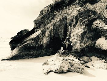 Rock formations on beach against sky