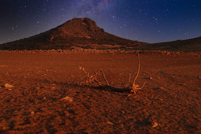Scenic view of arid landscape against sky at night