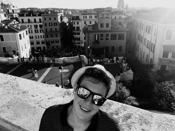 Portrait of man standing by buildings in city