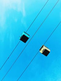 Low angle view of overhead cable car against blue sky