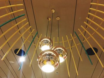 Low angle view of illuminated pendant lights hanging from ceiling