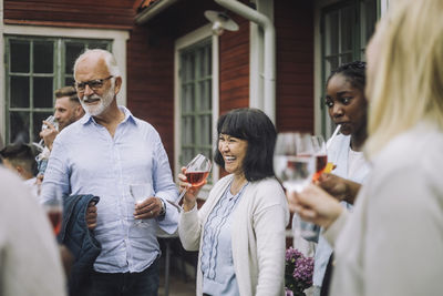 Happy woman holding wineglass with family during social gathering