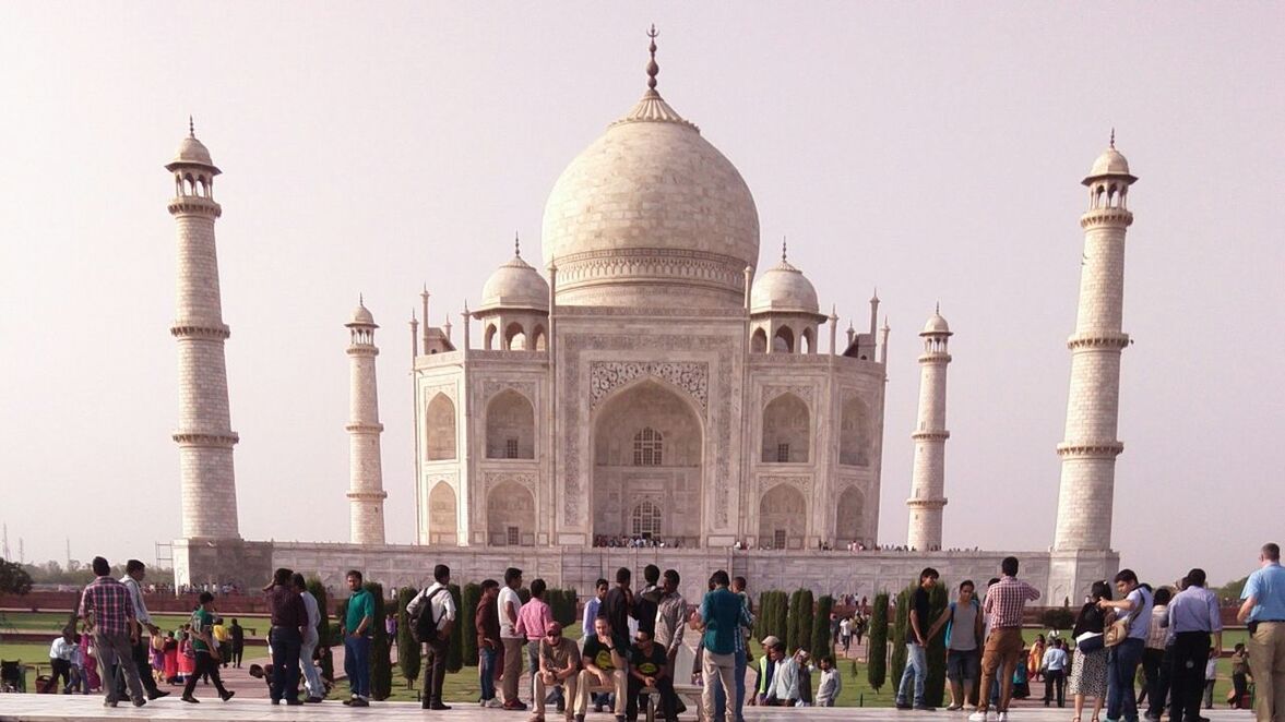 large group of people, tourism, memories, travel destinations, dome, tourist, facade, monument, famous place, international landmark, taj mahal, men, person, history, architecture, lifestyles, built structure, leisure activity, the past, building exterior, vacations, arch, travel, in front of, culture, clear sky, ancient, capital cities, sky, visiting, architectural feature, mausoleum