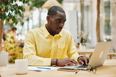 Young man using laptop at table