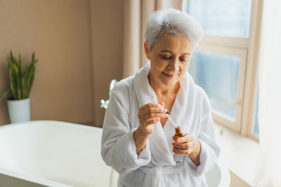 Portrait of senior man washing hands at home