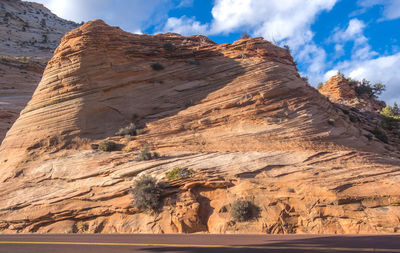 Scenic view of rock formations against cloudy sky