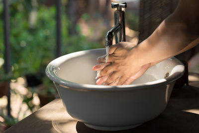 Close-up of hand holding bowl of water