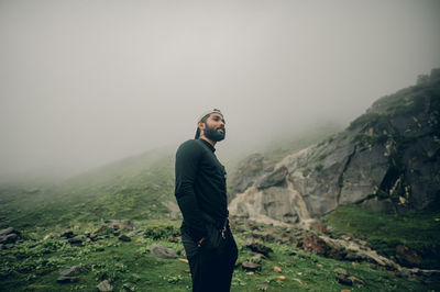 Rear view of man standing against mountain