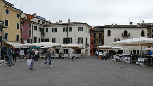 People on street against buildings in city