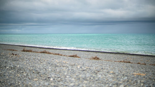 Scenic view of beach against cloudy sky