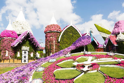 View of flowering plants in garden against building