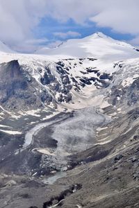 Scenic view of glacier and snowcapped mountains against sky
