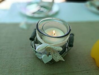 Close-up of illuminated candle on table