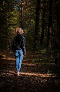 Rear view of woman standing in forest