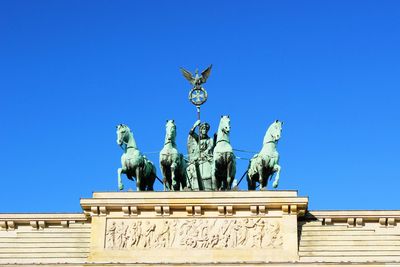 Low angle view of statue against blue sky