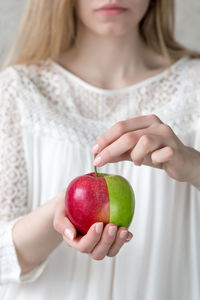 Midsection of woman holding apple