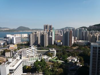 Aerial view of buildings in city against clear sky