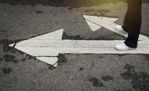 Low section of man standing on road