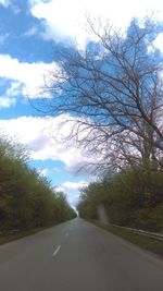 Road amidst trees against sky