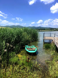 Boat moored in lake against sky
