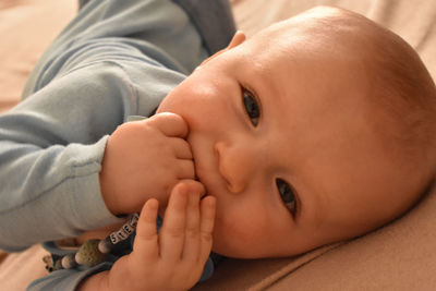 Close-up portrait of cute baby lying on bed