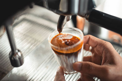 Close-up of hand holding coffee cup