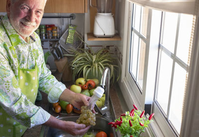 Midsection of man holding flower at home