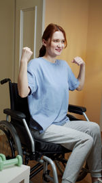Young smiling woman sitting on wheelchair