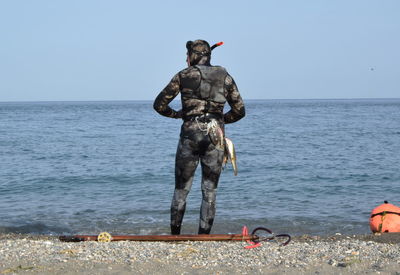 Rear view of a snorkeler standing on beach