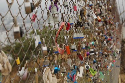 Close-up of padlocks hanging on chainlink fence