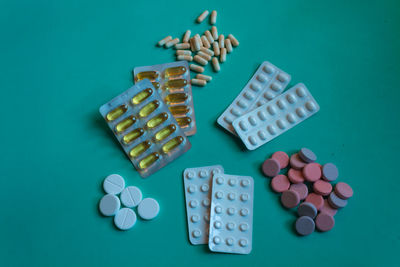 Directly above shot of various medicines on turquoise background