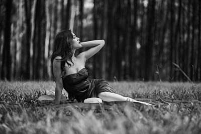 Young woman on field in forest