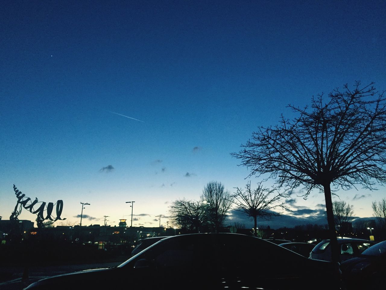 car, sky, transportation, mode of transport, land vehicle, blue, tree, no people, silhouette, clear sky, built structure, nature, illuminated, outdoors, architecture, star - space, day