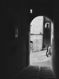 People walking on street seen through archway