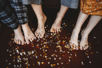 Confetti on legs of family and floorboard
